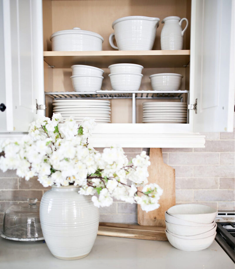 white kitchen cabinet of white dishes