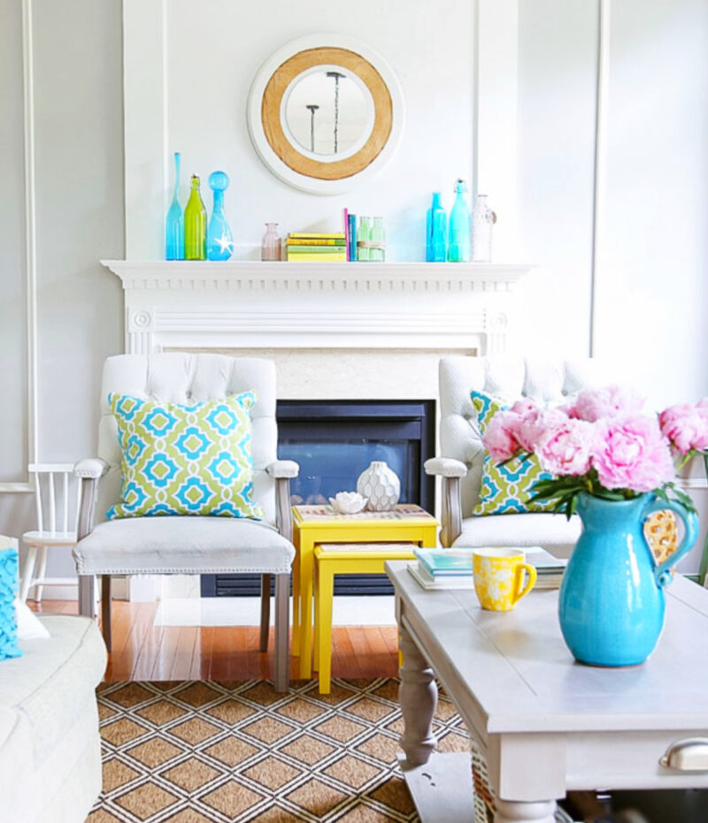 white living room with accessories in aqua and green and a yellow table and aqua pitcher with pink flowers