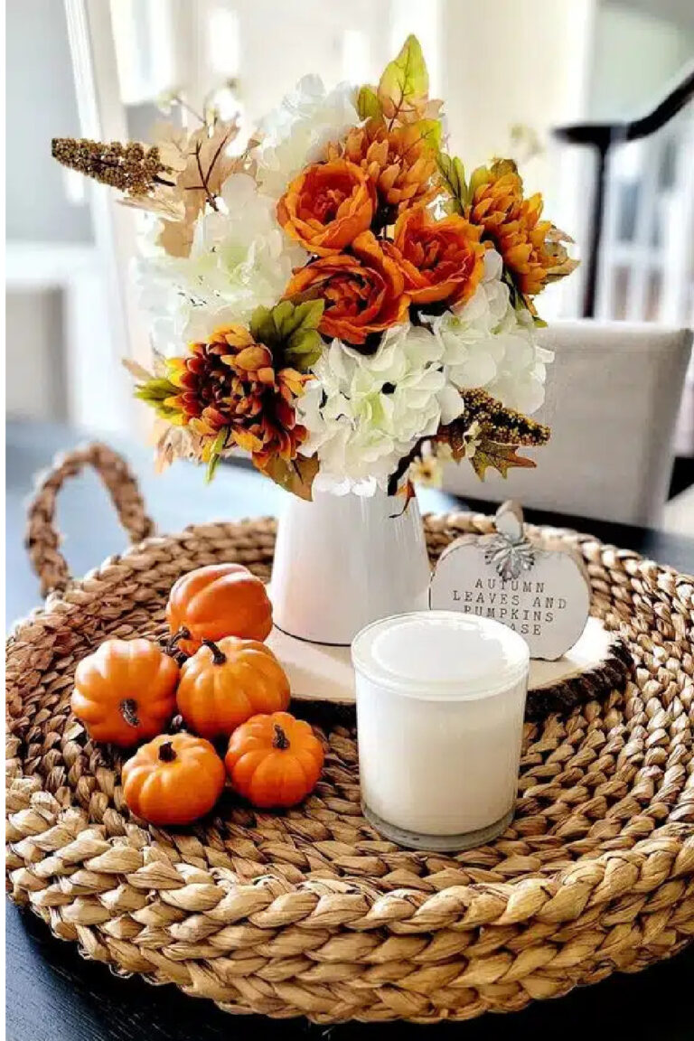 orange pumpkins and flowers with fall decor on woven tray