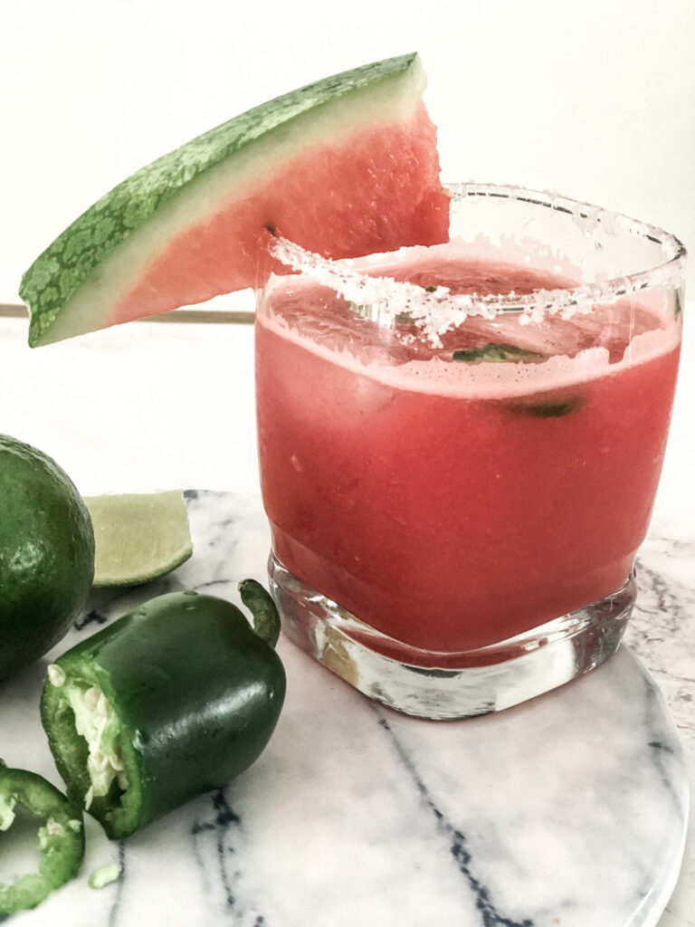 spicy watermelon margarita in short glass with salt rim