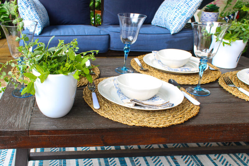 simple place setting with white dishes on woven placemat