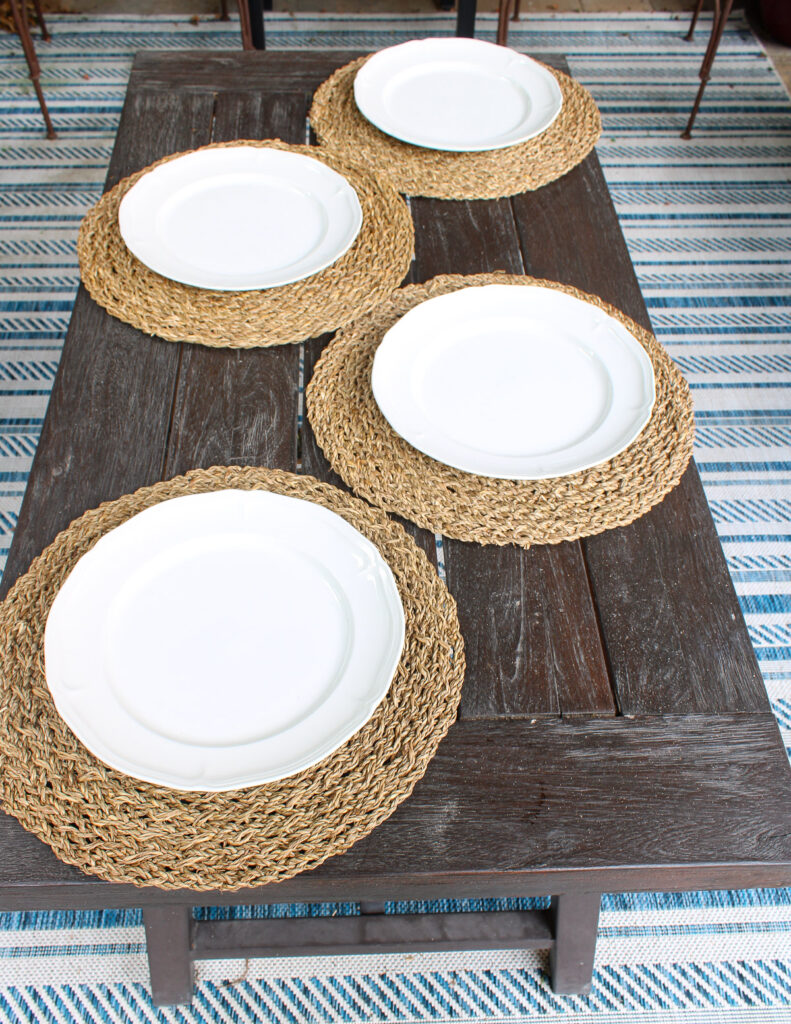 white dinner plates on woven placemats