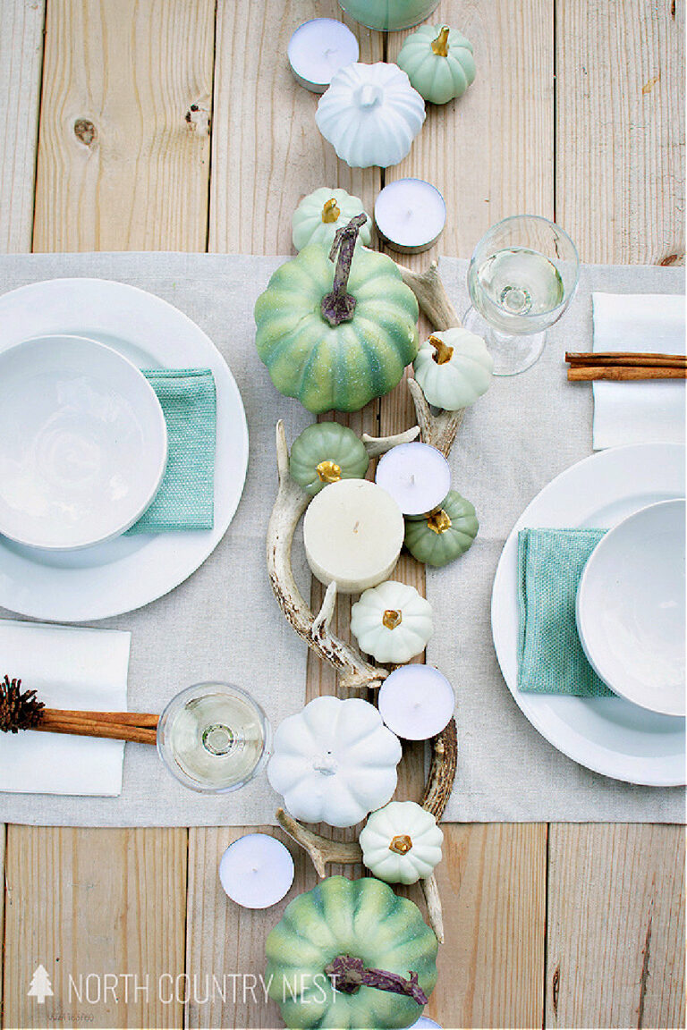 white dishes with aqua napkins and green pumpkin and white pumpkins on a fall table