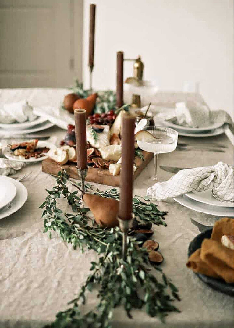 brown candles on a beige tablecloth with white dishes for a fall table