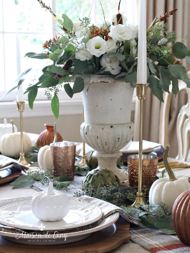 white chippy urn with candlesticks on a fall table