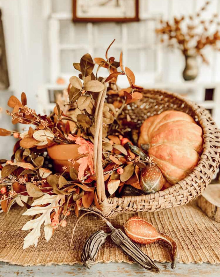 woven basket with dusty orange pumpkin and fall leaves