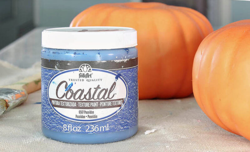 navy paint in jar with faux pumpkin in background