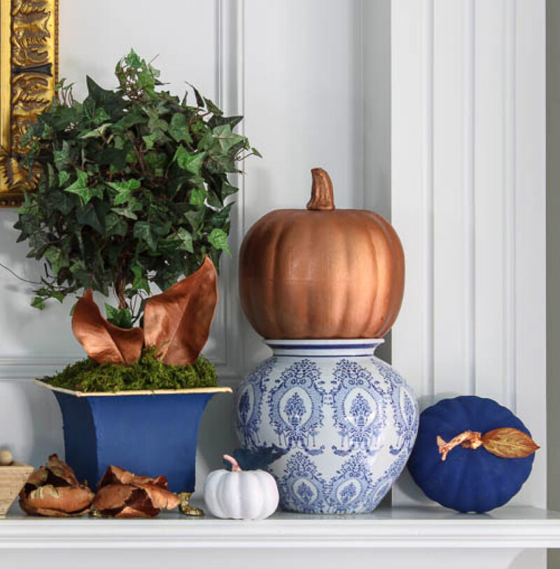 blue painted pumpkin on mantel with other fall elements