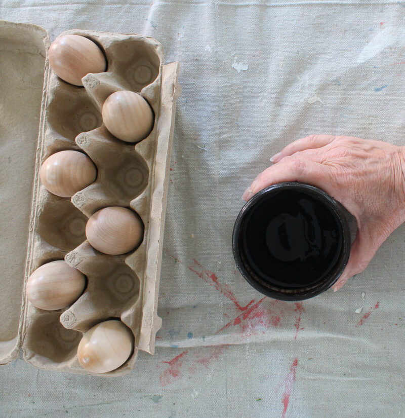 DIY faux acorns in paper carton with jar of brown stain