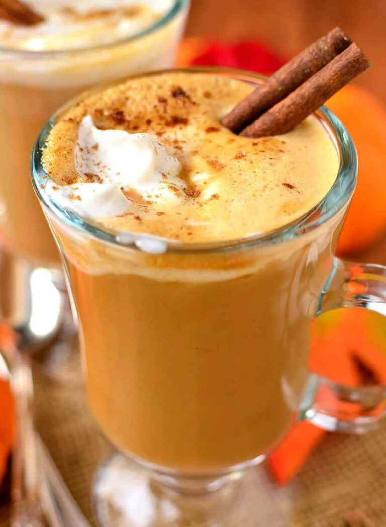 pumpkin spice latter in a tall glass with a cinnamon stick garnish