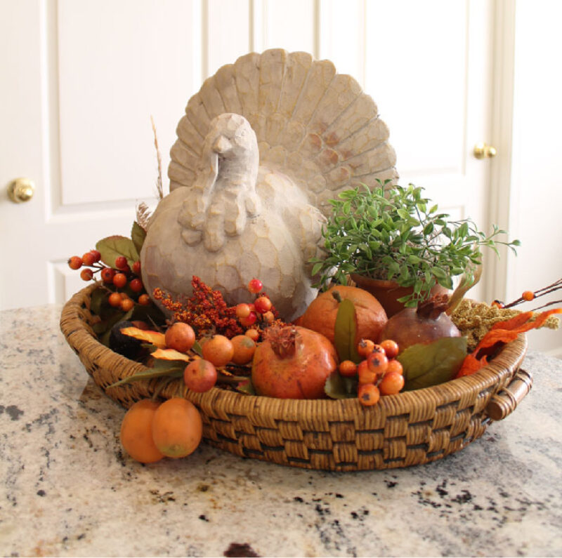 Thanksgiving centerpiece with large turkey and pumpkins on kitchen counter
