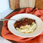 beef bouguignon with mashed potatoes in white bowl