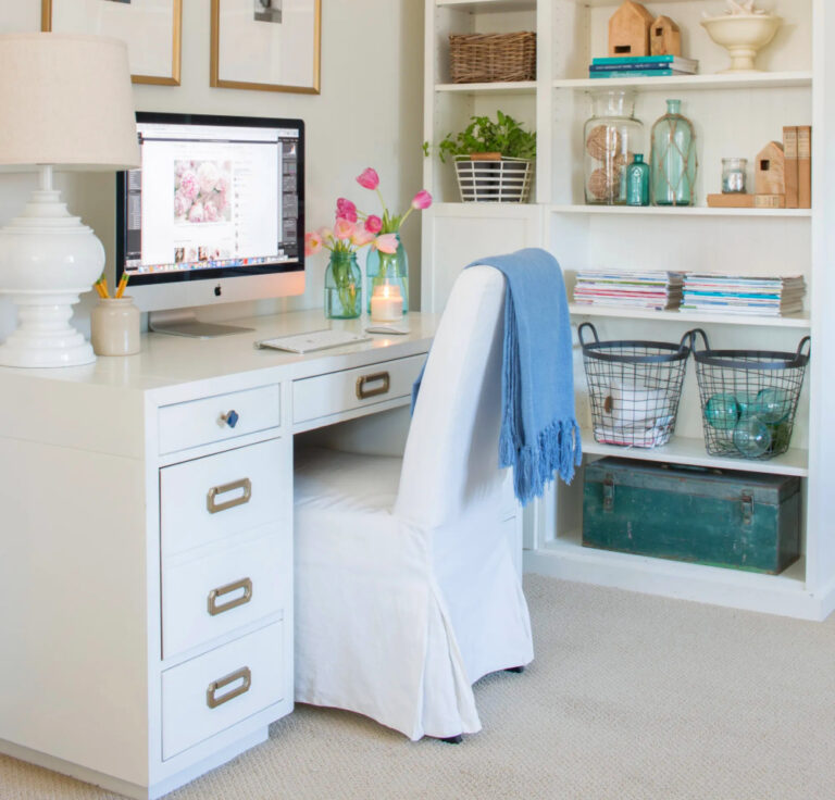 blue throw on white chair at desk with flowers