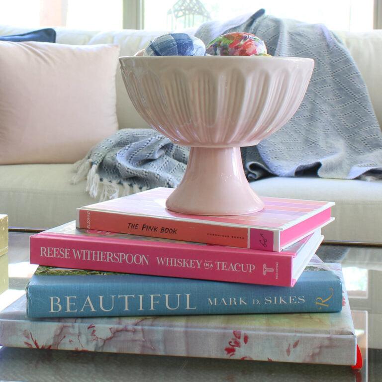 decoupage eggs in pink dish on stack of spring colored books