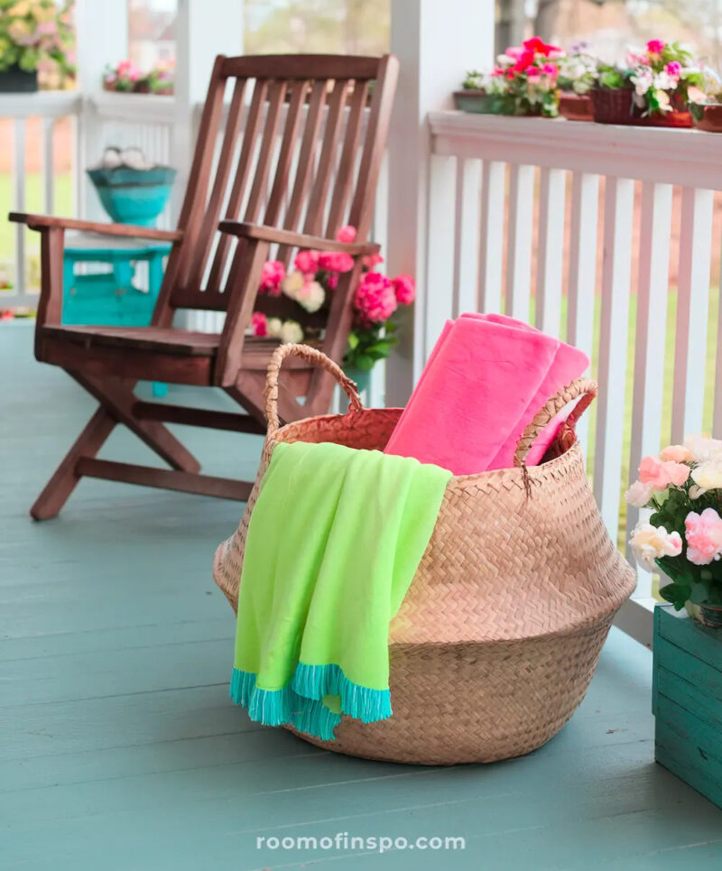 bright pink and green blankets in basket on spring front porch