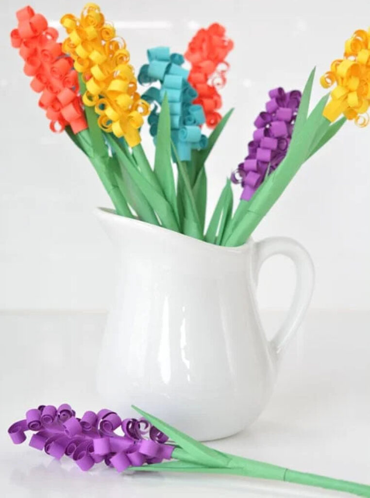 multi-colored paper hyacinths in white pitcher