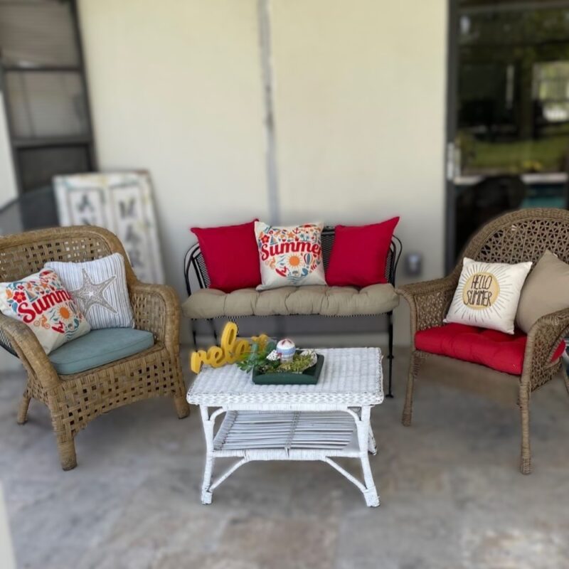 summer party on the patio with love seat, two chairs and white wicker table