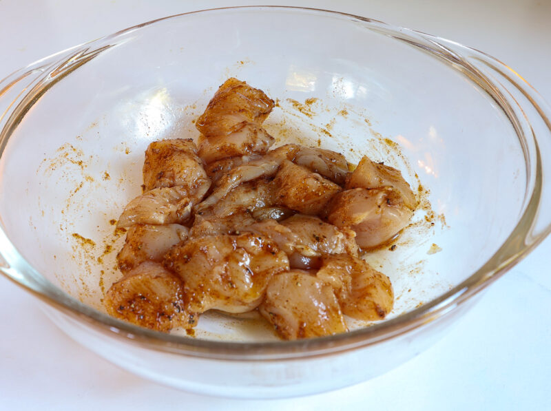 chicken cubes in bowl with spices