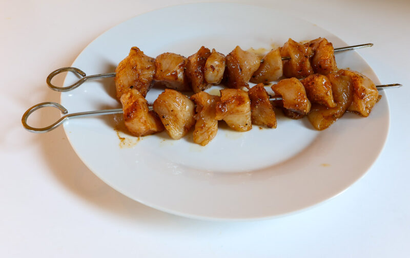 marinated chicken cubes on metal skewers