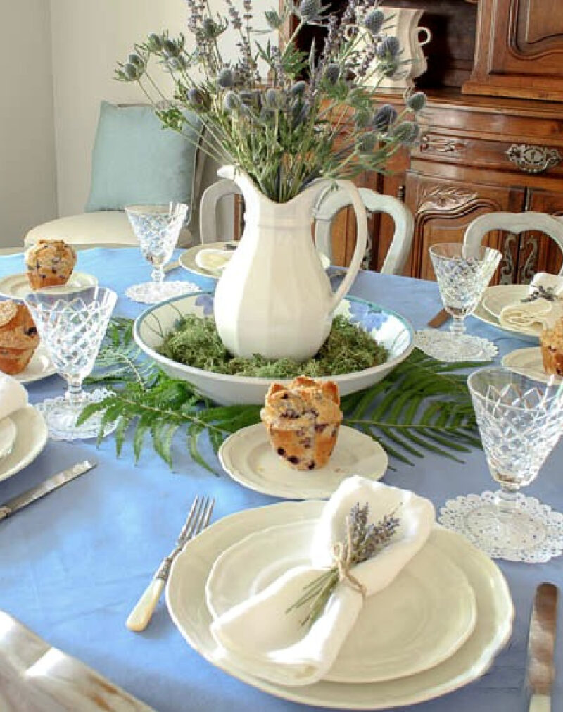 white pitcher with greenery and blue placemats