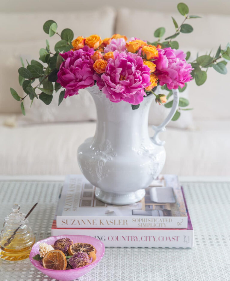 white vase filled with bright pink and orange summer flowers