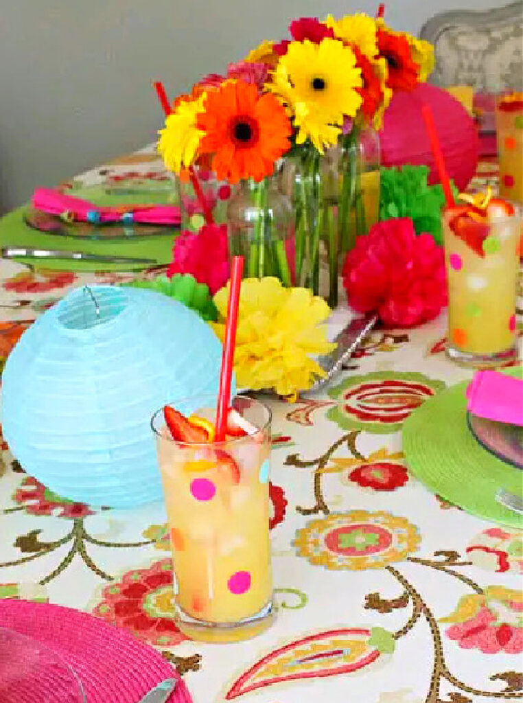 tropical tablescape with bright colors of aqua, orange, pink, and green