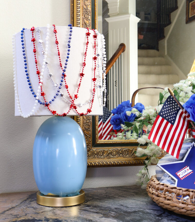 blue lamp with red, white, blue, and silver beads on it