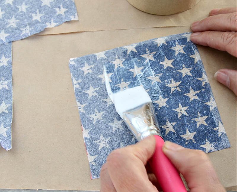 brushing blue napkin with stars with Mod Podge