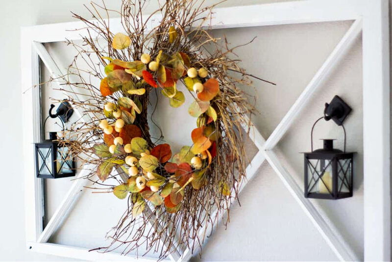 fall wreath hanging on white window frame