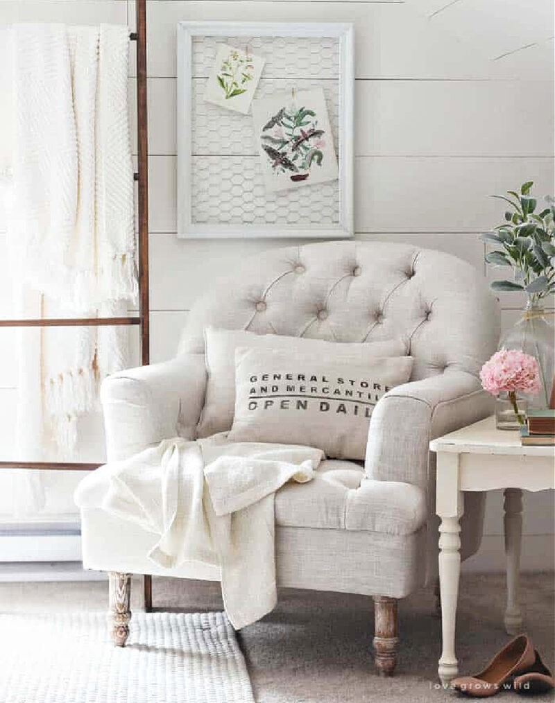 white upholstered chair with white throw and white side table