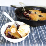 bowl of blackberry cobbler with a scoop of vanilla ice cream