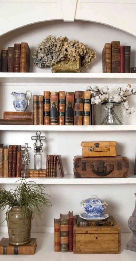 white bookcase filled with books in shades of brown and fall decor