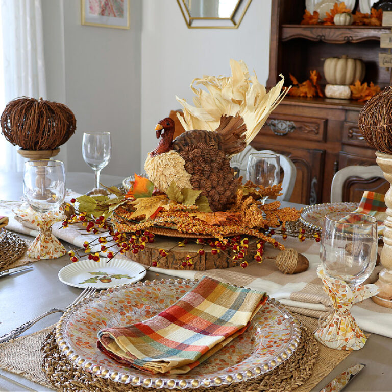 Thanksgiving centerpiece with turkey, twig pumpkin, and plaid napkin