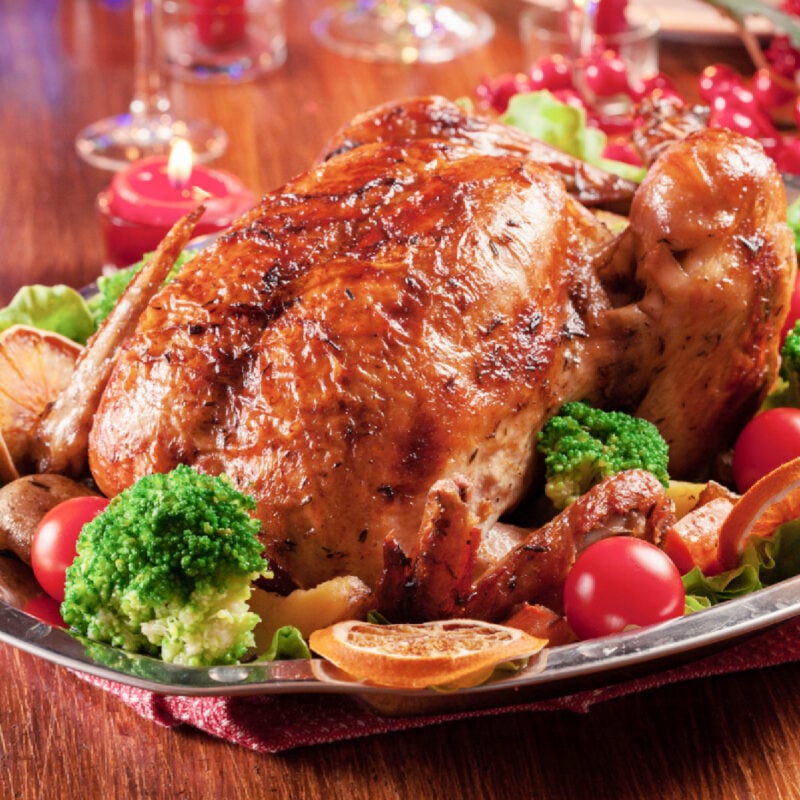 roasted turkey on platter with surrounded vegetables