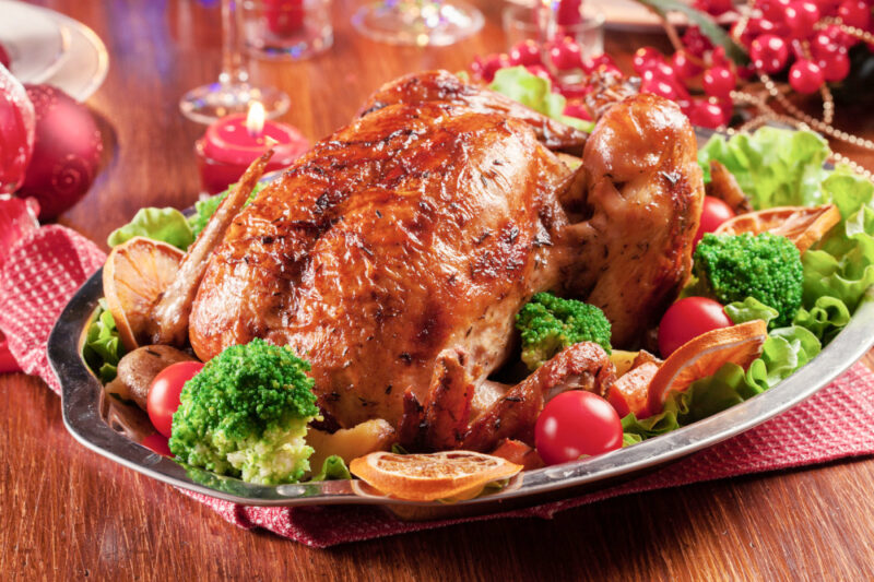 roasted turkey on a platter iwth surrounding vegetables