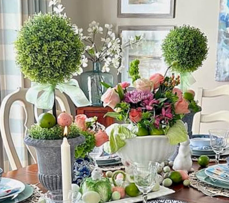 spring flowers in white vase with topiaries for centerpiece