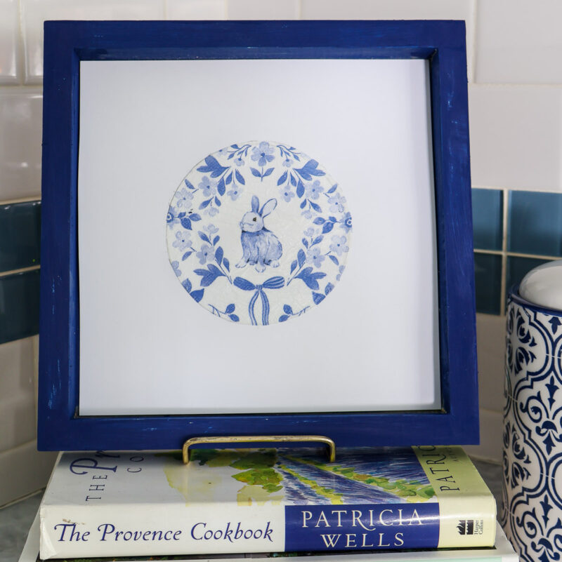 blue bunny design framed on stack of books in kitchen