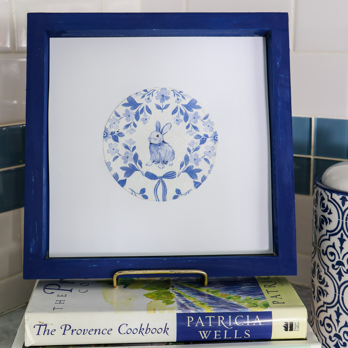 blue bunny design framed on stack of books in kitchen
