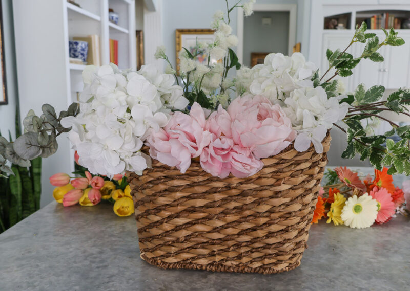 faux pink peonies in center front of basket
