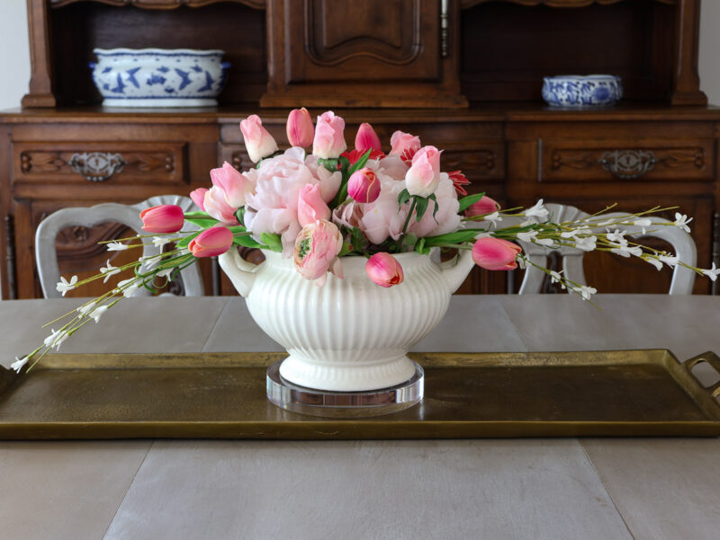 pink flower centerpiece on brass tray on dining room table