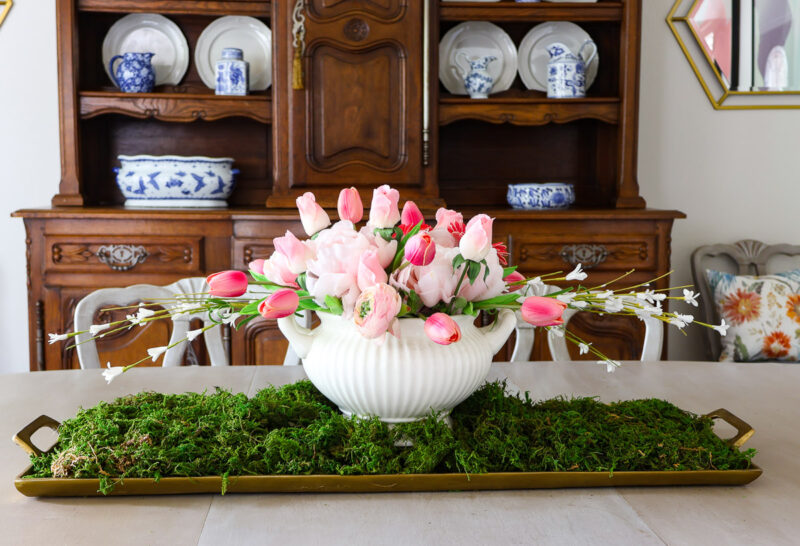 pink flower centerpiece on brass tray on dining room table