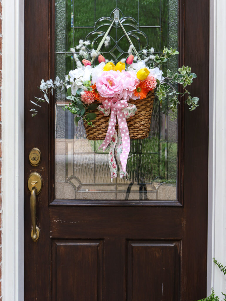 spring front door vignette with faux flower arrangement on from door