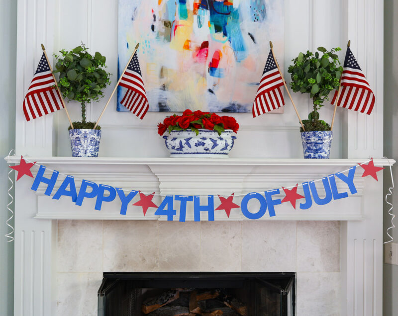 red and blue 4th of July banner on white mantel