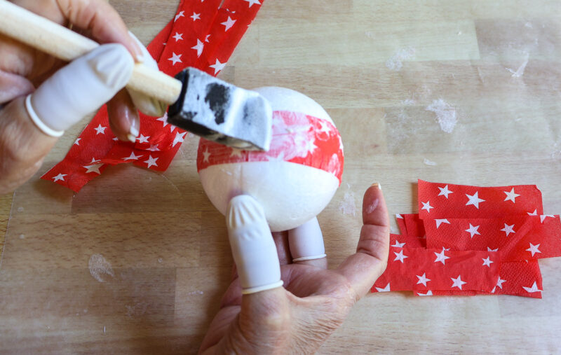 adding Mod Podge to strips of napkin