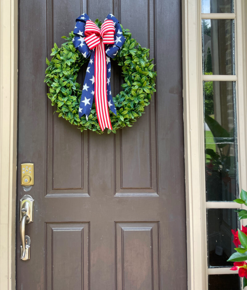 patriotic front door wreath with red and blue ribbon