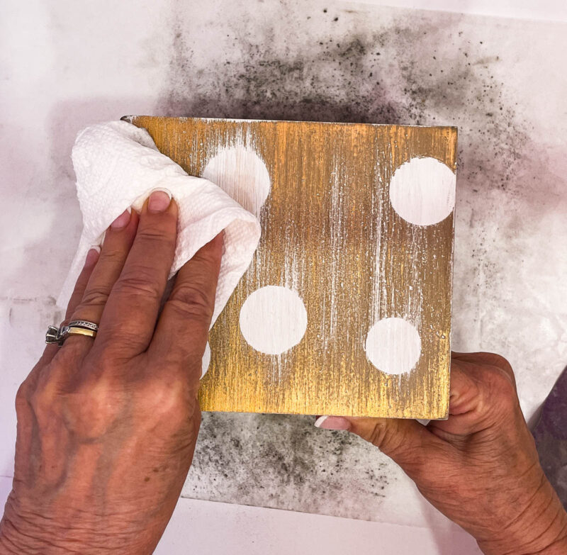 wiping dust off tissue box cover with paper towel