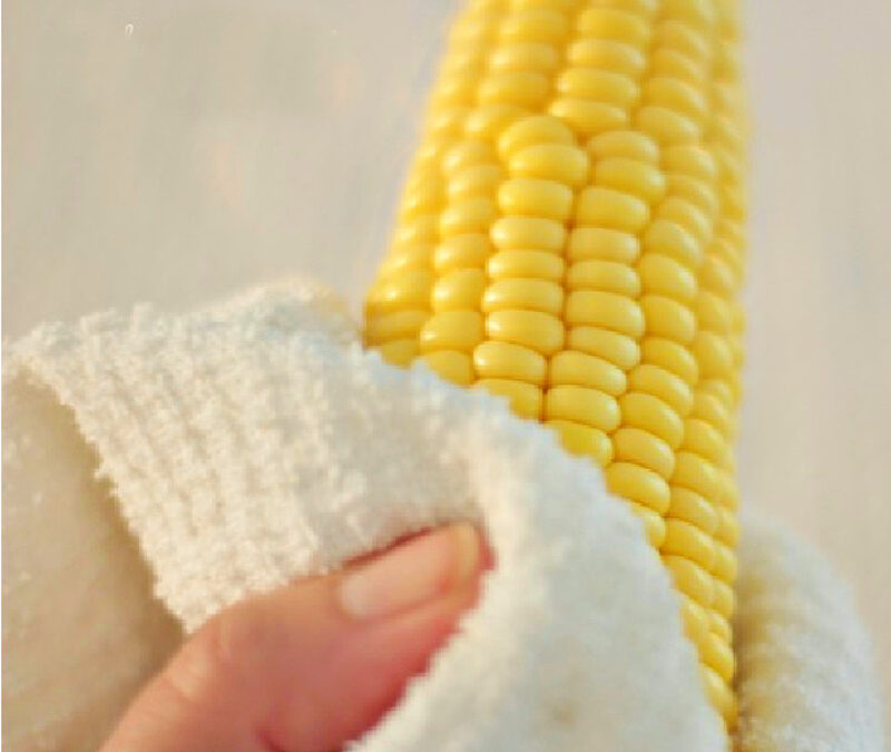 cleaning silks off corn on the cob with paper towel