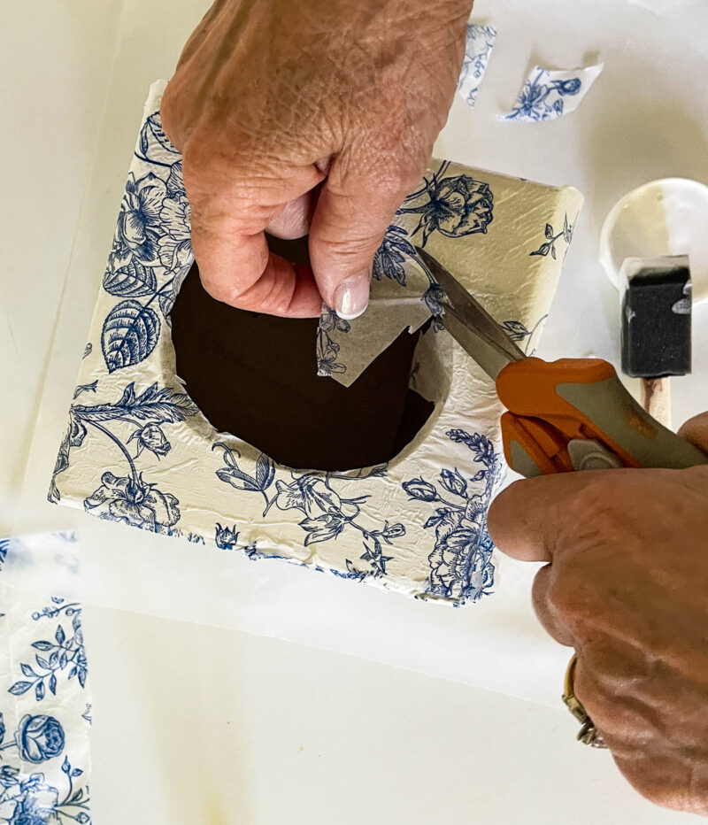 cutting excess paper on the top of the tissue box