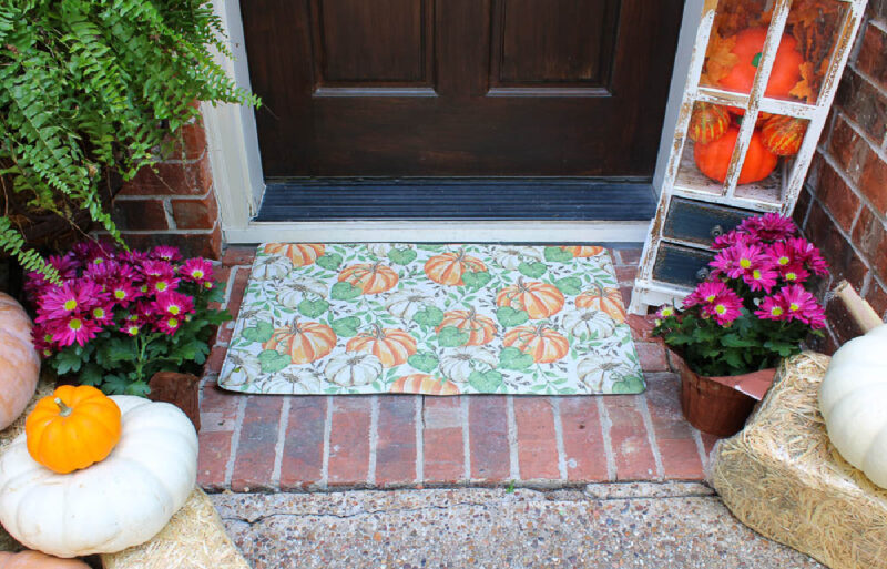front door with fall mat and lantern