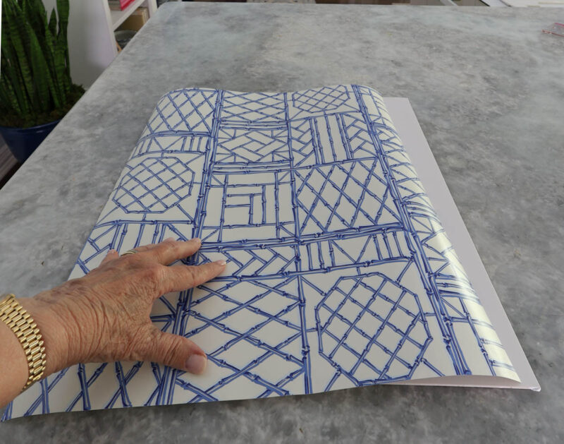 smoothing blue and white wrapping paper on foam board